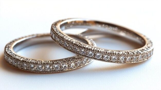 Two delicate diamond eternity rings with intricate migraine detailing in white gold, overlapping on a soft background.
